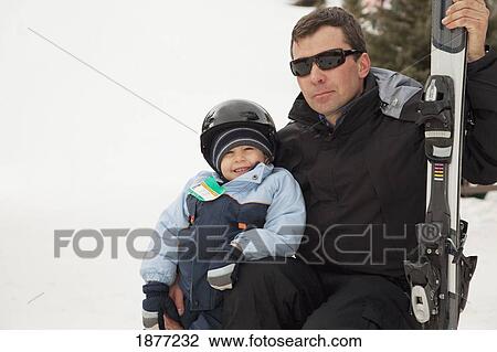 red deer, alberta, canada; a man with a young boy holding skis at a ski hill View Large Photo Image Stock Image - red deer, alberta, canada; a man with a young boy holding skis at a ski hill. Fotosearch