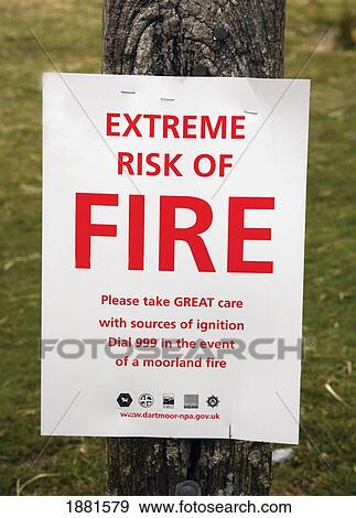 Stock Photo - sign 'extreme risk of fire' posted to a tree in dartmoor national park; devon, england. Fotosearch