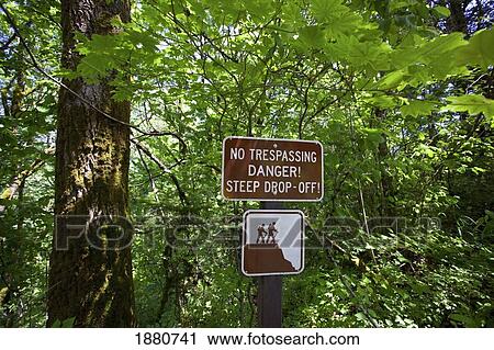 Stock Image - sign saying 'no trespassing danger steep drop-off! ' along columbia river old highway in columbia river gorge national scenic area; oregon, united states of america. Fotosearch