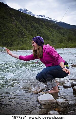 Stock Image - skagway, alaska, united states of america; a woman splashing and playing in the water. Fotosearch