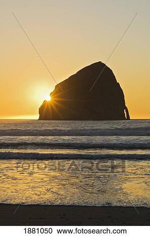 sunburst over haystack rock at cape kiwanda; pacific city, oregon, united states of america View Large Photo Image Stock Image - sunburst over haystack rock at cape kiwanda; pacific city, oregon, united states of america. Fotosearch