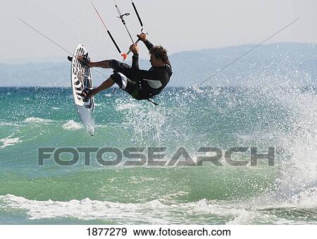 Stock Photo - tarifa, cadiz, andalusia, spain; a man kitesurfing off dos mares beach in front of hotel dos mares. Fotosearch
