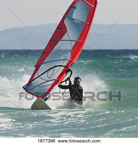 Stock Photograph - tarifa, cadiz, andalusia, spain; a man windsurfing. Fotosearch