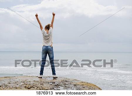 tarifa, cadiz, andalusia, spain; a woman with her arms raised in the air at hurricane hotel beach along costa de la luz View Large Photo Image Stock Image - tarifa, cadiz, andalusia, spain; a woman with her arms raised in the air at hurricane hotel beach along costa de la luz. Fotosearch