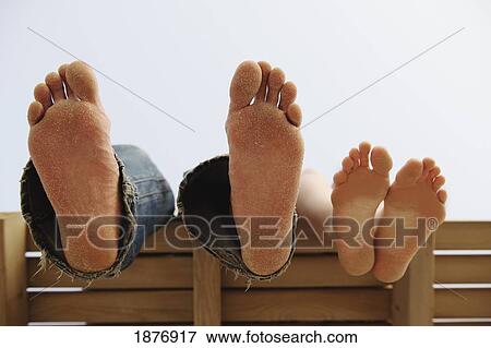 Stock Photo - tarifa, cadiz, andalusia, spain; bare feet propped up on a bench at los lances beach along costa de la luz. Fotosearch