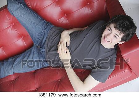 teenage boy relaxing on the sofa View Large Photo Image Stock Photo - teenage boy relaxing on the sofa. Fotosearch