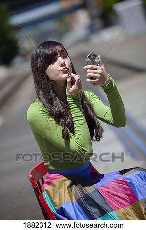 Stock Image - teenage girl applying lipstick; portland, oregon, united states of america. Fotosearch