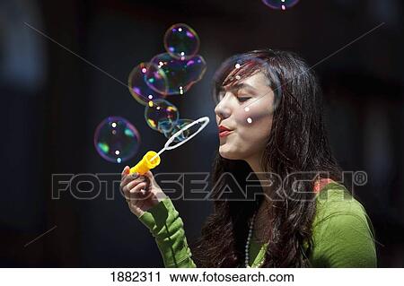 Stock Image - teenage girl blowing bubbles; portland, oregon, united states of america. Fotosearch