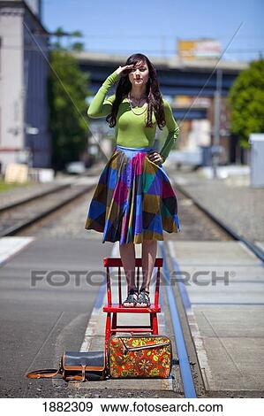 teenage girl standing on a chair looking for the train in downtown: portland, oregon, united states of america View Large Photo Image Stock Photo - teenage girl standing on a chair looking for the train in downtown: portland, oregon, united states of america. Fotosearch