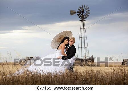 three hills, alberta, canada; a bride and groom in an embrace in a farm field View Large Photo Image Stock Photography - three hills, alberta, canada; a bride and groom in an embrace in a farm field. Fotosearch