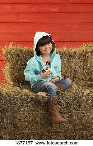 Stock Photo - three hills, alberta, canada; a young girl holding a bunny rabbit. Fotosearch