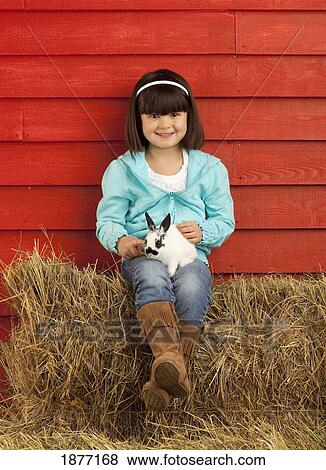 three hills, alberta, canada; a young girl holding a bunny rabbit View Large Photo Image Stock Photo - three hills, alberta, canada; a young girl holding a bunny rabbit. Fotosearch