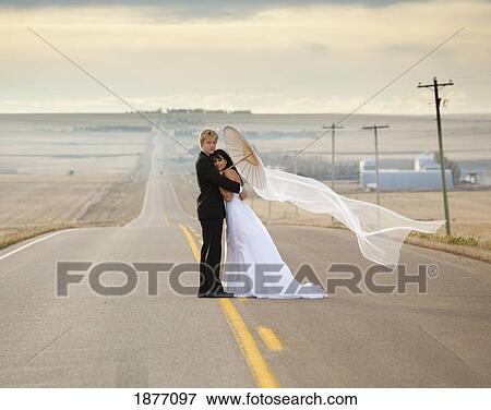 threehills, alberta, canada; bride and groom posing on a rural road View Large Photo Image Stock Photo - threehills, alberta, canada; bride and groom posing on a rural road. Fotosearch