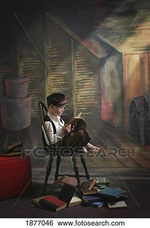 Stock Photograph - victoria, british columbia, canada; a boy posed reading old books. Fotosearch