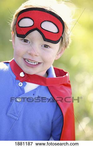 Stock Photo - young boy playing outdoors with a cape and a mask; portland, oregon, united states of america. Fotosearch