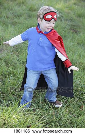 Stock Photograph - young boy playing outdoors with a cape and a mask; portland, oregon, united states of america. Fotosearch