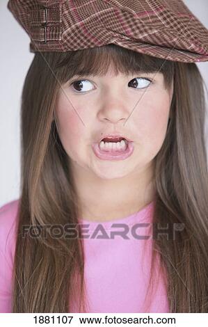 Stock Photo - young girl wearing a cap and doing a silly face. Fotosearch