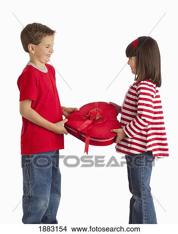 A Boy Gives A Heart Shaped Box To A Girl View Large Photo Image Picture - A Boy Gives A Heart Shaped Box To A Girl. Fotosearch