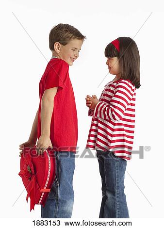 A Boy Hides A Heart Shaped Box Behind His Back For A Girl Standing In Front Of Him View Large Photo Image Stock Image - A Boy Hides A Heart Shaped Box Behind His Back For A Girl Standing In Front Of Him. Fotosearch
