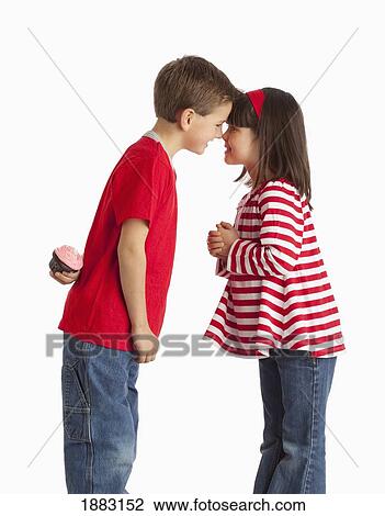 A Boy Hiding A Cupcake Behind His Back To Give To A Girl View Large Photo Image Stock Image - A Boy Hiding A Cupcake Behind His Back To Give To A Girl. Fotosearch