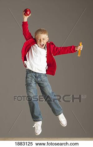 Stock Photography - A Boy Leaping In The Air Holding A Snack In His Hands. Fotosearch