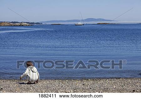 A Boy Plays With Rocks Along The Water's Edge; Langley, British Columbia, Canada View Large Photo Image Stock Image - A Boy Plays With Rocks Along The Water's Edge; Langley, British Columbia, Canada. Fotosearch