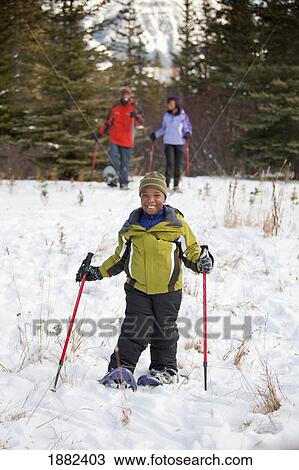 Stock Image - A Boy Skiing With His Parents; Lake Louise, Alberta, Canada. Fotosearch