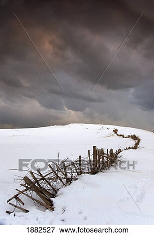 A Broken Fence Along A Snow Covered Field With Dark Clouds Overhead; South Shields, Tyne And Wear, England View Large Photo Image Stock Photo - A Broken Fence Along A Snow Covered Field With Dark Clouds Overhead; South Shields, Tyne And Wear, England. Fotosearch