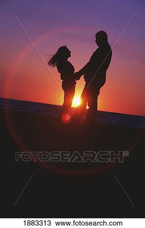 A Couple On The Water's Edge At Sunset; St. Catharines, Ontario, Canada View Large Photo Image Stock Image - A Couple On The Water's Edge At Sunset; St. Catharines, Ontario, Canada. Fotosearch