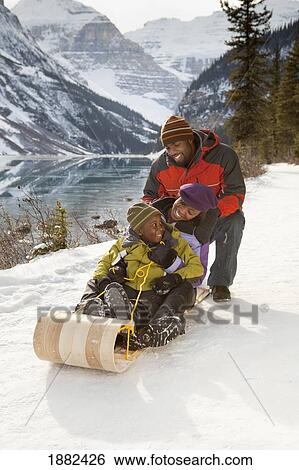 A Family Rides A Toboggan; Lake Louise, Alberta, Canada View Large Photo Image Stock Photograph - A Family Rides A Toboggan; Lake Louise, Alberta, Canada. Fotosearch