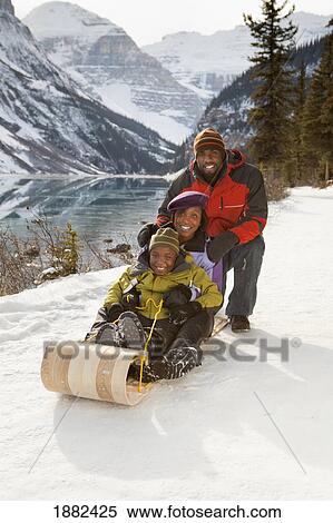 A Family Rides A Toboggan; Lake Louise, Alberta, Canada View Large Photo Image Stock Photography - A Family Rides A Toboggan; Lake Louise, Alberta, Canada. Fotosearch