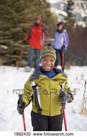 Stock Image - A Family Skiing In The Mountains; Lake Louise, Alberta, Canada. Fotosearch