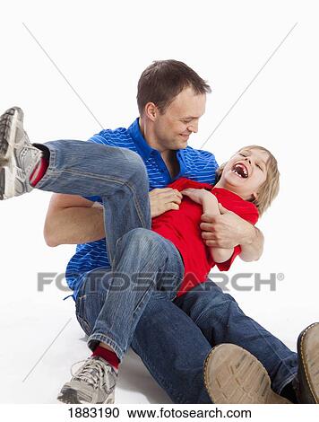 Stock Image - A Father Tickling His Son. Fotosearch