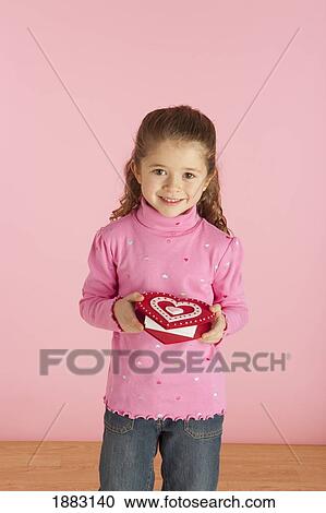 Stock Image - A Girl Holding A Heart Shaped Box. Fotosearch