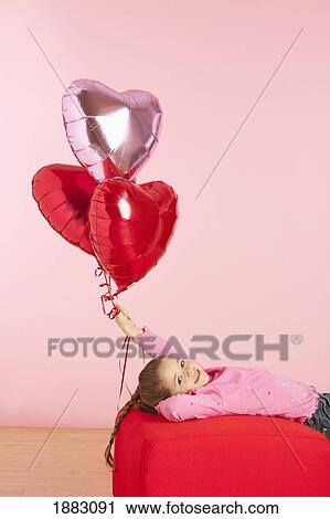 A Girl Holding Three Heart Shaped Balloons View Large Photo Image Stock Image - A Girl Holding Three Heart Shaped Balloons. Fotosearch