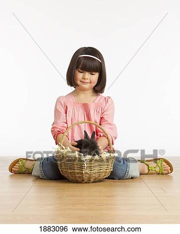 A Girl Petting A Rabbit In A Basket View Large Photo Image Stock Photograph - A Girl Petting A Rabbit In A Basket. Fotosearch