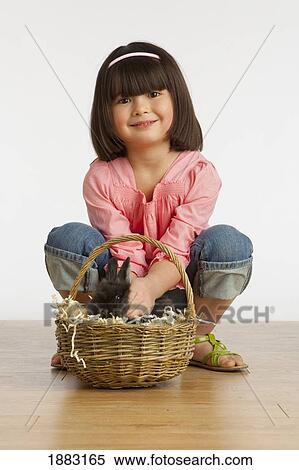 A Girl Petting A Rabbit In A Basket View Large Photo Image Stock Photography - A Girl Petting A Rabbit In A Basket. Fotosearch