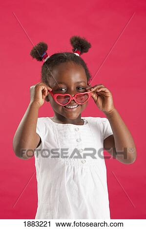 A Girl Putting On Heart Shaped Glasses View Large Photo Image Stock Image - A Girl Putting On Heart Shaped Glasses. Fotosearch