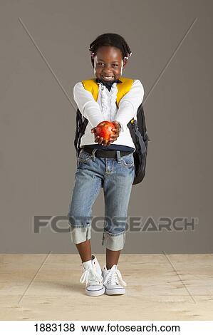 A Girl With A Backpack Holding An Apple View Large Photo Image Stock Photo - A Girl With A Backpack Holding An Apple. Fotosearch