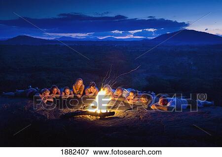 A Group Of People Laying In A Row By A Campfire; Manica, Mozambique, Africa View Large Photo Image Stock Photo - A Group Of People Laying In A Row By A Campfire; Manica, Mozambique, Africa. Fotosearch