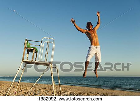 Stock Image - A Man Jumping In The Air On Dos Mares Beach In Front Of Hotel Dos Mares; Tarifa, Cadiz, Andalusia, Spain. Fotosearch