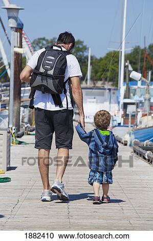 A Man Walking With His Young Son Down A Pier At The Harbor; Langley, British Columbia, Canada View Large Photo Image Stock Image - A Man Walking With His Young Son Down A Pier At The Harbor; Langley, British Columbia, Canada. Fotosearch