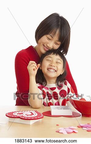 Stock Image - A Mother And Daughter Making Valentine's Day Crafts. Fotosearch