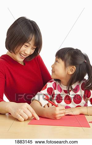 A Mother And Daughter Writing A Note On Red Paper View Large Photo Image Stock Photography - A Mother And Daughter Writing A Note On Red Paper. Fotosearch