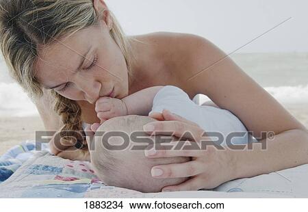 A Mother Laying On A Blanket On The Beach With Her Baby; Benalmadena Costa, Costa Del Sol, Malaga, Andalusia, Spain View Large Photo Image Picture - A Mother Laying On A Blanket On The Beach With Her Baby; Benalmadena Costa, Costa Del Sol, Malaga, Andalusia, Spain. Fotosearch