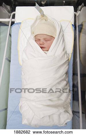 Stock Image - A Newborn Baby Wrapped In A Blanket Wearing A Cap In The Hospital; Millet, Alberta, Canada. Fotosearch