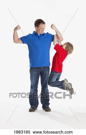 A Son Hanging Off His Father As He Flexes His Muscles View Large Photo Image Stock Photography - A Son Hanging Off His Father As He Flexes His Muscles. Fotosearch
