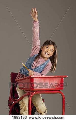 A Student At Her Desk With Her Hand Raised View Large Photo Image Stock Image - A Student At Her Desk With Her Hand Raised. Fotosearch