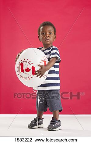 Stock Image - A Young Boy Holding A Balloon With A Picture Of The Canada Flag. Fotosearch
