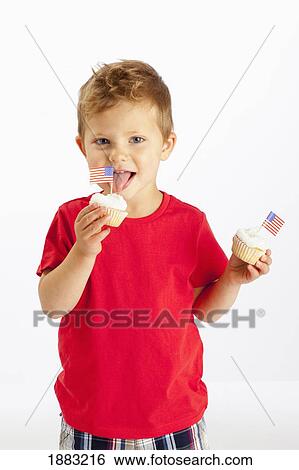 A Young Boy Holds Two Cupcakes With American Flags In Them View Large Photo Image Stock Photograph - A Young Boy Holds Two Cupcakes With American Flags In Them. Fotosearch